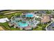 An aerial view displays a resort-style pool, sun loungers, cabanas, and lush landscaping at 1521 Flange Dr, Davenport, FL 33896