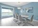 Dining area featuring modern table, seating for six, an outdoor view, stylish mirror decor, and marble floors at 1521 Flange Dr, Davenport, FL 33896