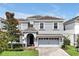 Elegant two-story home with a well-manicured lawn, tile roof, and charming front porch at 1521 Flange Dr, Davenport, FL 33896