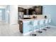 Modern kitchen with dark cabinetry, stainless steel appliances, and a breakfast bar at 1521 Flange Dr, Davenport, FL 33896