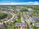 Aerial view of a community with a sparkling lake, fountain, clubhouse, green spaces, and well-maintained homes at 15822 Woodland Spring Ct, Orlando, FL 32828