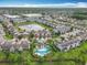 Beautiful aerial view of the neighborhood featuring a community pool, pond with fountain, and manicured lawns at 15822 Woodland Spring Ct, Orlando, FL 32828