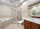Bathroom showcasing a bathtub with tile surround and a glass-enclosed shower for a relaxing and modern space at 15822 Woodland Spring Ct, Orlando, FL 32828