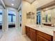 Bathroom with vanity, mirror, walk-in closet and view of bedroom, creating a suite experience at 15822 Woodland Spring Ct, Orlando, FL 32828