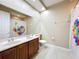 Modern bathroom featuring a double sink vanity, a large mirror, and stylish colorful patterned shower curtain at 15822 Woodland Spring Ct, Orlando, FL 32828