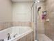 Close-up of bathtub and shower stall with tile surround, creating a spa-like retreat for relaxation at 15822 Woodland Spring Ct, Orlando, FL 32828