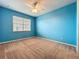 Bright carpeted bedroom with neutral trim features a ceiling fan and a large window with blinds at 15822 Woodland Spring Ct, Orlando, FL 32828