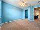 Bright bedroom featuring beige carpet, neutral trim, a ceiling fan, and an ample walk-in closet at 15822 Woodland Spring Ct, Orlando, FL 32828