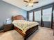 Cozy bedroom with wooden bed frame, ceiling fan, and abundant natural light from multiple windows at 15822 Woodland Spring Ct, Orlando, FL 32828