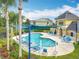 Community pool surrounded by manicured grounds and featuring ample seating and shaded area at 15822 Woodland Spring Ct, Orlando, FL 32828