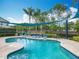 Sparkling community pool with clear turquoise water, surrounded by lounge chairs and shaded by a blue awning at 15822 Woodland Spring Ct, Orlando, FL 32828