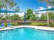 Inviting community pool featuring ample deck space, shaded area and clear turquoise water at 15822 Woodland Spring Ct, Orlando, FL 32828
