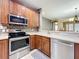 Modern kitchen with stainless steel appliances and wood cabinets, perfect for cooking and entertaining at 15822 Woodland Spring Ct, Orlando, FL 32828