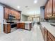 Spacious kitchen with stainless steel appliances, wood cabinets, and an open view to the living room at 15822 Woodland Spring Ct, Orlando, FL 32828