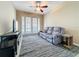Relaxing living room featuring a comfortable gray sofa, ceiling fan, and access to the patio at 15822 Woodland Spring Ct, Orlando, FL 32828