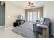 Casual living room with patio access and a comfortable gray sofa with ceiling fan overhead at 15822 Woodland Spring Ct, Orlando, FL 32828