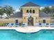 Community pool and pool house with lounge chairs surrounding the inviting clear, blue swimming pool at 15822 Woodland Spring Ct, Orlando, FL 32828