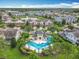 Aerial view of community pool with sunshades and lounge chairs surrounded by lush trees and Gathering-friendly homes at 15822 Woodland Spring Ct, Orlando, FL 32828