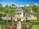 Inviting community pool house featuring lush landscaping, palms, and decorative accents at 15822 Woodland Spring Ct, Orlando, FL 32828