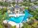 A beautiful community pool surrounded by lounge chairs, cabanas, and lush landscaping in a Gathering neighborhood at 15822 Woodland Spring Ct, Orlando, FL 32828