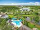 Aerial view of a community pool surrounded by a lake, trees and homes in a Gathering-friendly neighborhood at 15822 Woodland Spring Ct, Orlando, FL 32828