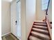 Entryway with carpeted stairs and a white front door, complemented by natural light at 15822 Woodland Spring Ct, Orlando, FL 32828