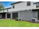 Townhome backyard featuring a small patio area, grass, and an AC unit at 1624 Little Wren Ln, Winter Park, FL 32792