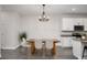 Open dining area with hardwood floors, modern chandelier, and adjacent kitchen at 1624 Little Wren Ln, Winter Park, FL 32792