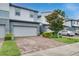 Modern townhome showcasing a two-car garage and neatly landscaped front yard on a sunny day at 1624 Little Wren Ln, Winter Park, FL 32792