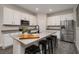 Modern kitchen with white cabinets, gray countertops, stainless steel appliances, and a breakfast bar at 1624 Little Wren Ln, Winter Park, FL 32792