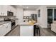 Bright kitchen featuring white cabinets, gray countertops, stainless steel appliances and a breakfast bar at 1624 Little Wren Ln, Winter Park, FL 32792