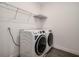 A laundry room with wood-look flooring featuring a washer, dryer, and wire shelving at 1624 Little Wren Ln, Winter Park, FL 32792