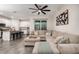 Open-concept living area with a sectional couch, modern fan, and breakfast bar leading to the kitchen at 1624 Little Wren Ln, Winter Park, FL 32792