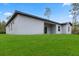 Home's backyard with lush green grass, complemented by a sleek, modern exterior at 17397 Sw 41St Cir, Ocala, FL 34473