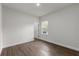 Minimalist bedroom showing hardwood floors, a window, and an open door at 17397 Sw 41St Cir, Ocala, FL 34473