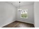 Dining room with natural light, dark laminate floors and a modern chandelier to add style to the space at 17397 Sw 41St Cir, Ocala, FL 34473