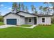 Beautiful single-story home boasts a well-kept lawn and landscaping, complemented by a modern, eye-catching blue garage door at 17397 Sw 41St Cir, Ocala, FL 34473