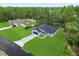 Aerial view of a light blue single-Gathering home featuring a well-manicured lawn and attached two-car garage at 17397 Sw 41St Cir, Ocala, FL 34473