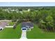 Aerial view of a light blue single-Gathering home with a large, grassy front yard, surrounded by trees at 17397 Sw 41St Cir, Ocala, FL 34473