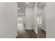 Bright hallway with modern wood floors leading to an open-concept living area and a bathroom at 17397 Sw 41St Cir, Ocala, FL 34473