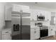 Kitchen boasts stainless steel appliances, quartz countertops, and bright white cabinets, providing a clean aesthetic at 17397 Sw 41St Cir, Ocala, FL 34473