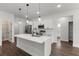 Bright kitchen features white cabinets, stainless appliances, an island, and a modern pendant lighting system at 17397 Sw 41St Cir, Ocala, FL 34473