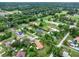Overhead view features a neighborhood with lovely lawns, mature trees, and homes with private swimming pools at 1778 Woodcrest Ln, Deland, FL 32720