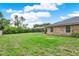 This backyard features a green lawn and a screened-in pool at 1778 Woodcrest Ln, Deland, FL 32720