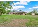 Wide view of a ranch-style home with a sprawling lawn, two-car garage, and storage building at 1778 Woodcrest Ln, Deland, FL 32720