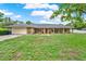 Ranch-style home with a brick facade, attached garage, and a well-manicured front lawn at 1778 Woodcrest Ln, Deland, FL 32720