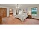 The primary bedroom features warm neutral walls, ensuite access, and bright windows overlooking the landscaping at 1778 Woodcrest Ln, Deland, FL 32720