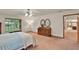 Bright main bedroom with a ceiling fan, large window, and wooden dresser with decorative mirrors at 1778 Woodcrest Ln, Deland, FL 32720