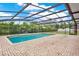 Backyard features a screened in pool with brick pavers and a surrounding green yard at 1778 Woodcrest Ln, Deland, FL 32720