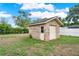 Tan brick shed with garage door in backyard and blue skies at 1778 Woodcrest Ln, Deland, FL 32720